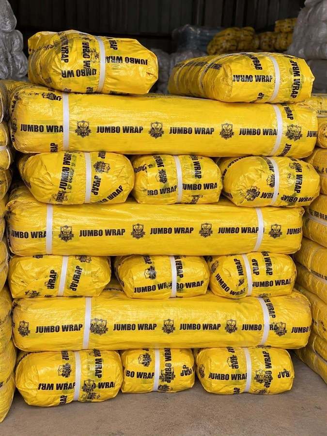 Stacks of yellow Jumbo Wrap tarpaulin rolls in stock